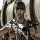 Charlize Theron holds a gun as Furiosa in Mad Max: Fury Road.